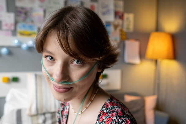 Gezicht van tiener meisje met zuurstof pijp in haar neus - Foto, afbeelding