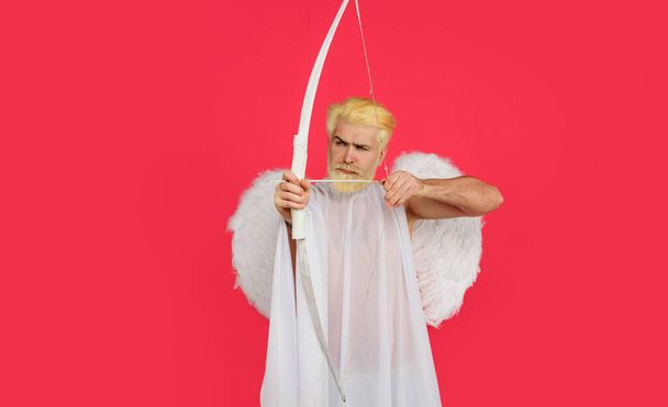 Cupidon avec arc et flèche. Joyeuse Saint-Valentin. Un homme sérieux aux ailes d'ange. Amour. Dieu d'amour. - Photo, image