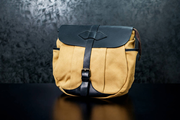 Yellow fabric bag with leather on a dark background - Фото, зображення