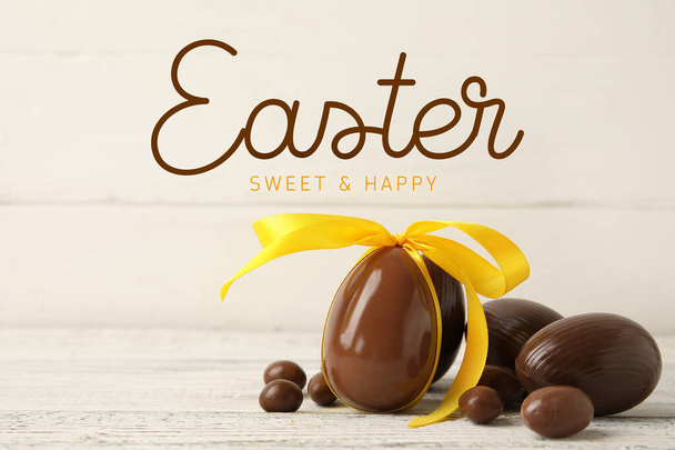 Tasty chocolate eggs on white wooden background. Happy Easter celebration - Photo, Image