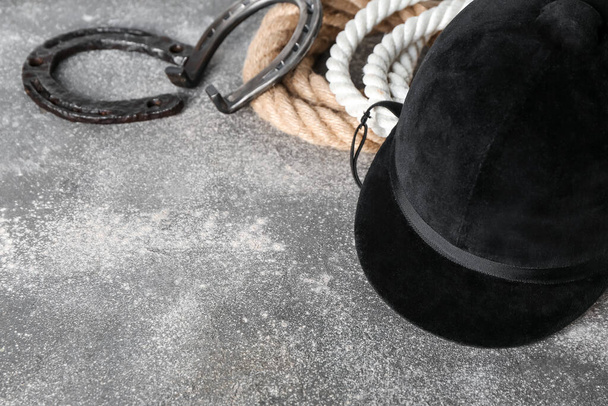 Шлем для верховой езды и подковы с веревками на фоне гранжа - Фото, изображение