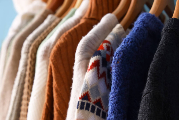 Closeup view of hangers with stylish knitted sweaters - Fotoğraf, Görsel