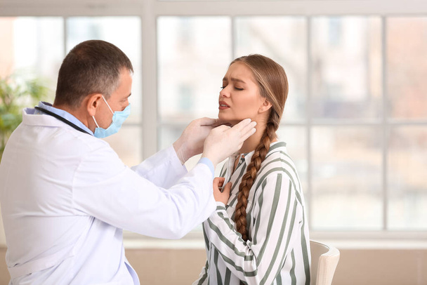 Doctor examining woman's neck in clinic - Fotó, kép
