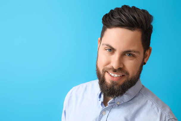 Стильний бородатий чоловік на синьому фоні
 - Фото, зображення