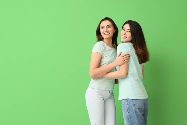 Beautiful hugging women on green background - Photo, Image
