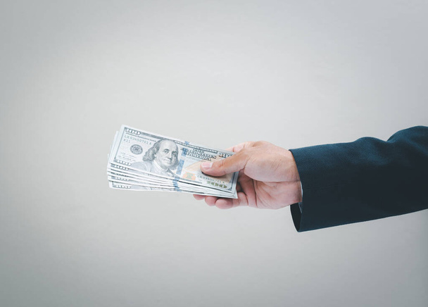 Businessman hand holding usd. dollar banknote. Business and financial concept. - Photo, Image