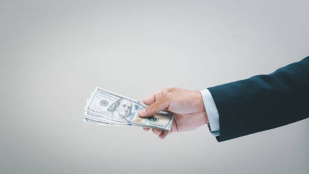 Businessman hand holding usd. dollar banknote. Business and financial concept. - Zdjęcie, obraz