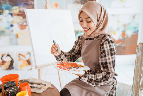 muslim asian female artist painting on canvas - Fotoğraf, Görsel
