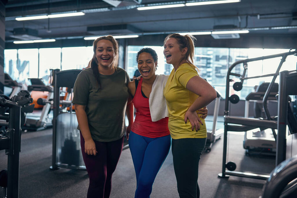 Multiracial girls hug und look at camera im gym - Foto, Bild