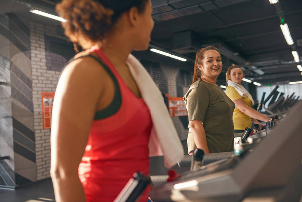 Multiracial girls running on treadmill in gym - Fotó, kép