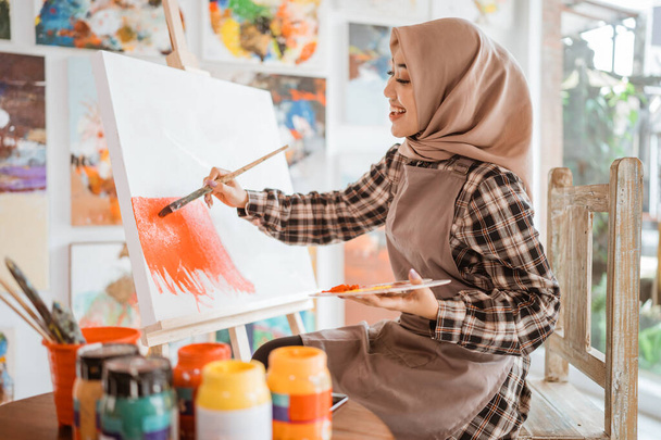muslim asian female artist painting on canvas - Fotografie, Obrázek