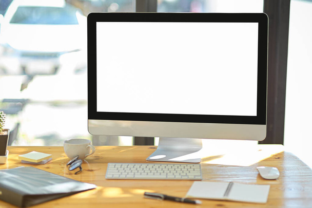 Современный офисный стол с настольным компьютером белый экран монитор, устройства, канцтовары и канцелярские принадлежности на деревянном столе. Концепция компьютера  - Фото, изображение