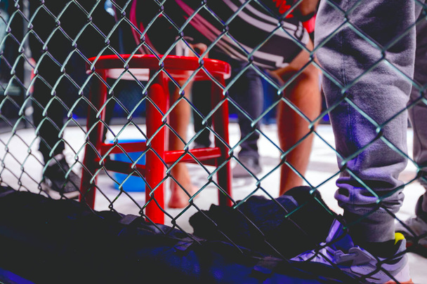 Näkymä läpi lanka taistelevat rengas pieni punainen nyrkkeilijä tuoli lepää taistelijoita välillä taistelee. - Valokuva, kuva