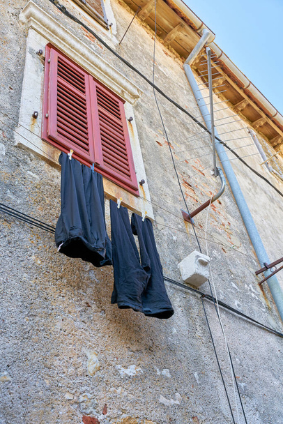 Γραμμή ρούχων με παντελόνι σε πρόσοψη στην παλιά πόλη Κρκ της Κροατίας - Φωτογραφία, εικόνα