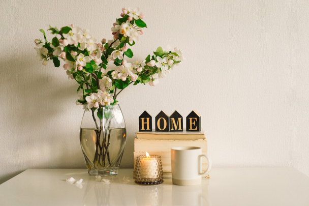 Libro, candela e vaso con fiori di mela primaverile. - Foto, immagini