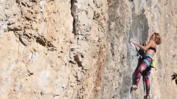 όμορφο κορίτσι σκαρφαλώνει στο βράχο - Πλάνα, βίντεο