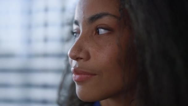 Nuori musta tukka nainen etsii ajatellut liike-uran ikkunassa toimistossa - Materiaali, video