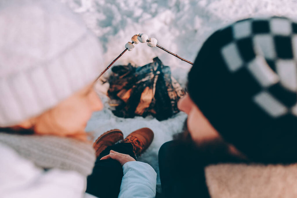 Couple in love fry marshmallows at stake. winter theme - Фото, зображення
