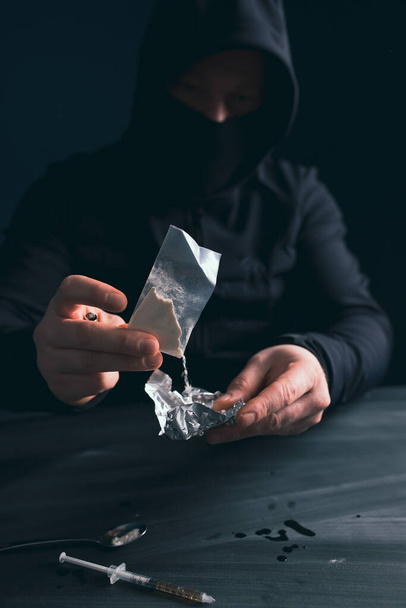 Addict/junkie man preparing drugs. The concept of crime and drug addiction. - Photo, image