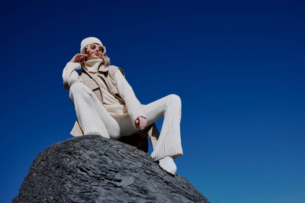τουρίστας το φθινόπωρο ρούχα στέκεται σε ένα βράχο τοπίο μπλε ουρανό χαλάρωση - Φωτογραφία, εικόνα