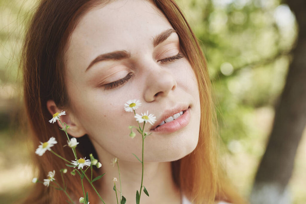 retrato de uma bela mulher com flores silvestres e com olhos fechados na natureza em um prado - Foto, Imagem