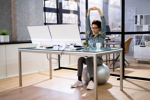 Businesswoman Sitting On Fitness Ball Working In Office - Foto, Bild