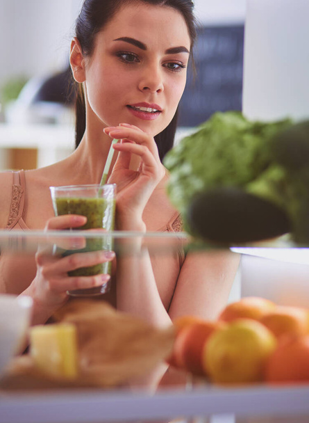 Young woman with glass of tasty healthy smoothie at table in kitchen - Fotografie, Obrázek