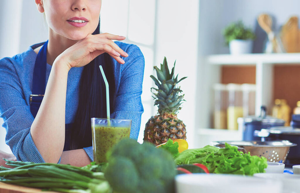 Young woman with glass of tasty healthy smoothie at table in kitchen - Photo, image