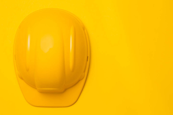 yellow construction helmet on a yellow background, head protection, concept - Zdjęcie, obraz