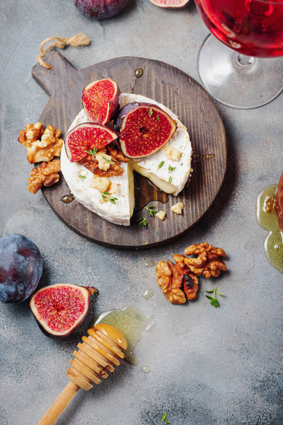 baked camembert cheese with figs, thyme, nuts and honey. glass of red wine - Foto, imagen