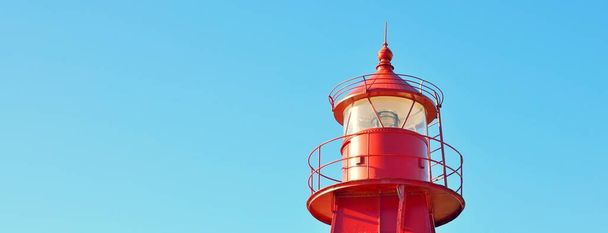 Punainen majakka kirkasta sinistä taivasta vasten, lähikuva. Tanska, Eurooppa. Matkakohteet, maamerkki, navigointi, meri, toivon ja rauhan symboli, graafiset resurssit - Valokuva, kuva