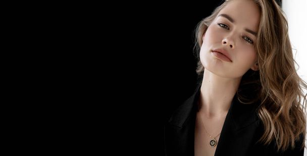 Natural look. Beauty model woman . Model test portrait with young beautiful fashion model posing on grey background. Blond woman in a black blazer . Natural makeup - 写真・画像