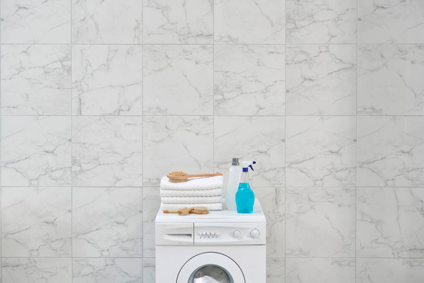 Закрыть стиральную машину в стиле с инструментом, щеткой и комплектами для уборки в стене ванной комнаты. - Фото, изображение