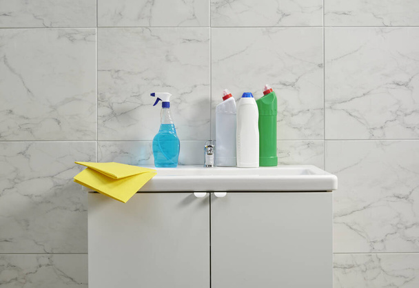 Kits de nettoyage sur l'évier de l'armoire dans la salle de bain, tissu jaune, gros plan. - Photo, image