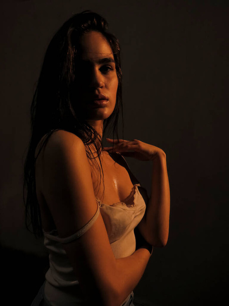 Portrait of a dark-haired young nude woman with smooth tanned skin in water droplets, sexuality and beauty, aesthetics and health of the female body - Foto, Imagem