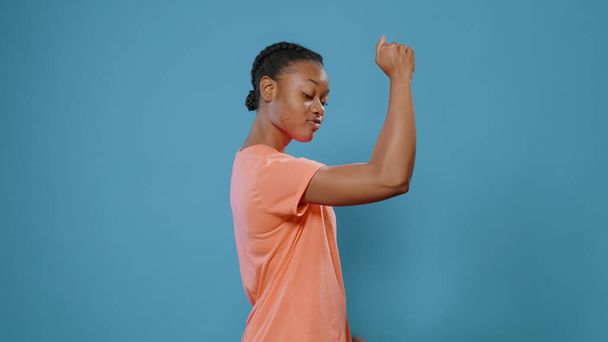 Deportiva mujer flexión entrenado los músculos del brazo delante de la cámara - Foto, imagen
