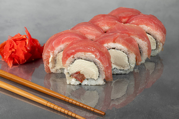 Sushi met Uramaki, Californie, Philadelphie, roule sur une plaque blanche. Menu pour restaurants, cafés. Sur un fond sombre réfléchissant. - Photo, image