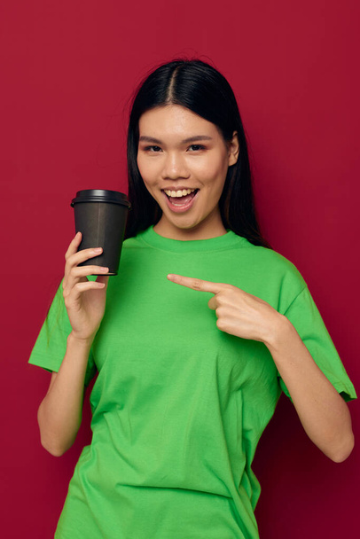 Charmante junge Asiatin posiert in grünem T-Shirt Einweg-schwarze Brille Studiomodell unverändert - Foto, Bild