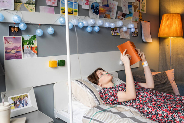 Sick woman reading a book at hospital ward - Fotografie, Obrázek