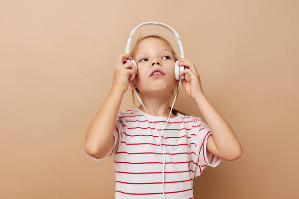 pretty young girl in striped t-shirt headphones gesture hands childhood unaltered - Фото, изображение