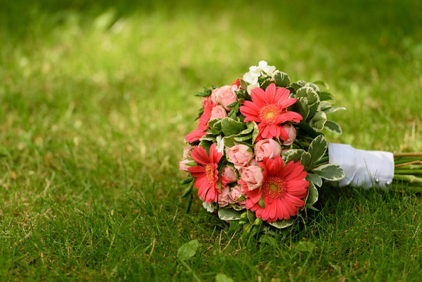 Un bouquet de mariage coloré posé sur l'herbe avec un espace de copie autour - Photo, image