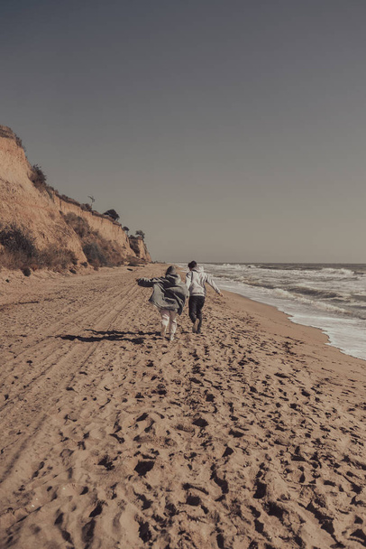 Man and woman enjoy each other, run along the seashore - Фото, зображення