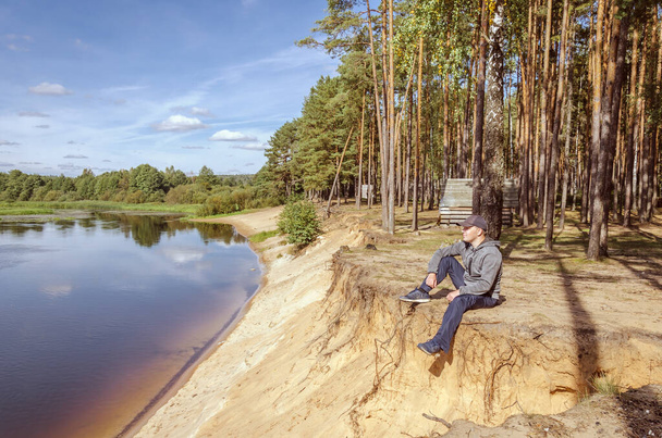 Guy relaxes in nature near the river. Beautiful landscape outdoor recreation. - Fotoğraf, Görsel