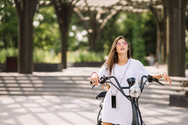 Jovem mulher bonita e uma scooter elétrico, transporte ecológico - Foto, Imagem