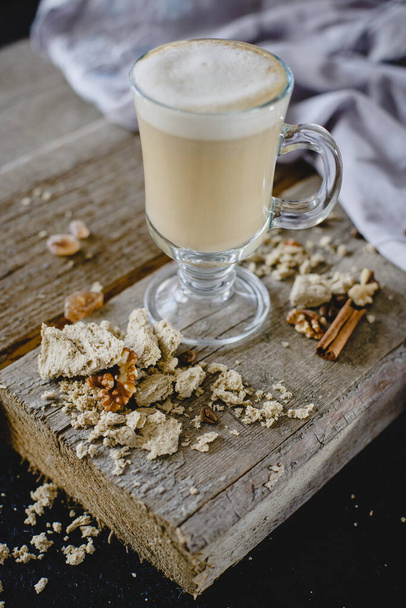 Coffee Latte cappuccino Raf and ice in a beautiful glass on a textured wooden table with cinnamon and mint - Foto, Bild