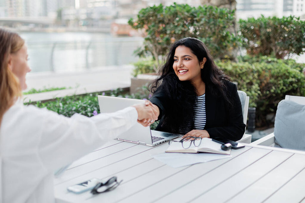 Two businesswomen make a deal during a meeting in a cafe. Business, work meeting, work outside the office. - Photo, Image