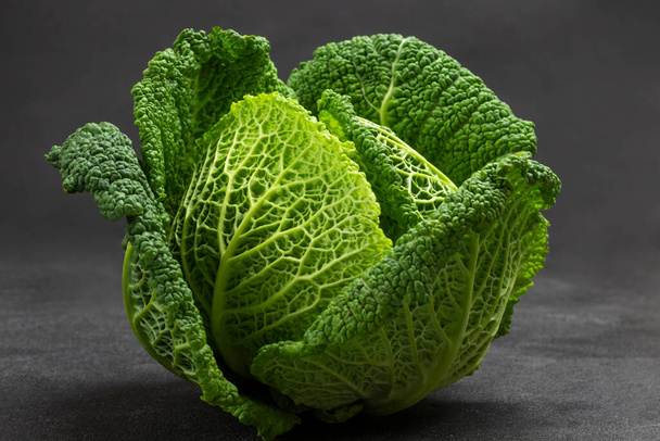 Green Savoy cabbage close up. Top view. Black background - Photo, image
