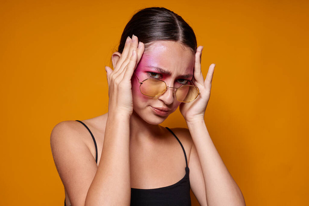 Young beautiful woman fashion glasses pink face makeup posing attractive look isolated background unaltered - Zdjęcie, obraz