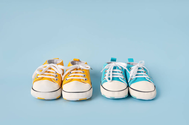 Baby's little sneakers on a colorful background. The concept of waiting for a baby and the concept of traveling with baby, children's lifestyle. Copy space, flat lay - Foto, Imagem