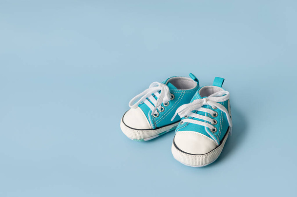 Las pequeñas zapatillas de bebé sobre un fondo colorido. El concepto de esperar a un bebé y el concepto de viajar con el bebé, estilo de vida de los niños. Copiar espacio, plano laico - Foto, Imagen